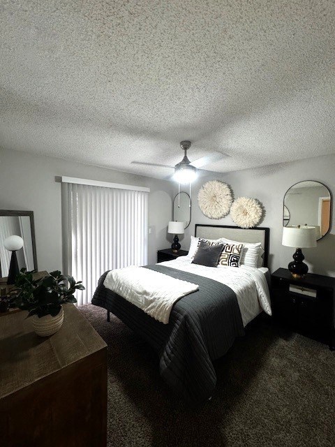 A bedroom with a bed, nightstand, and a ceiling fan.