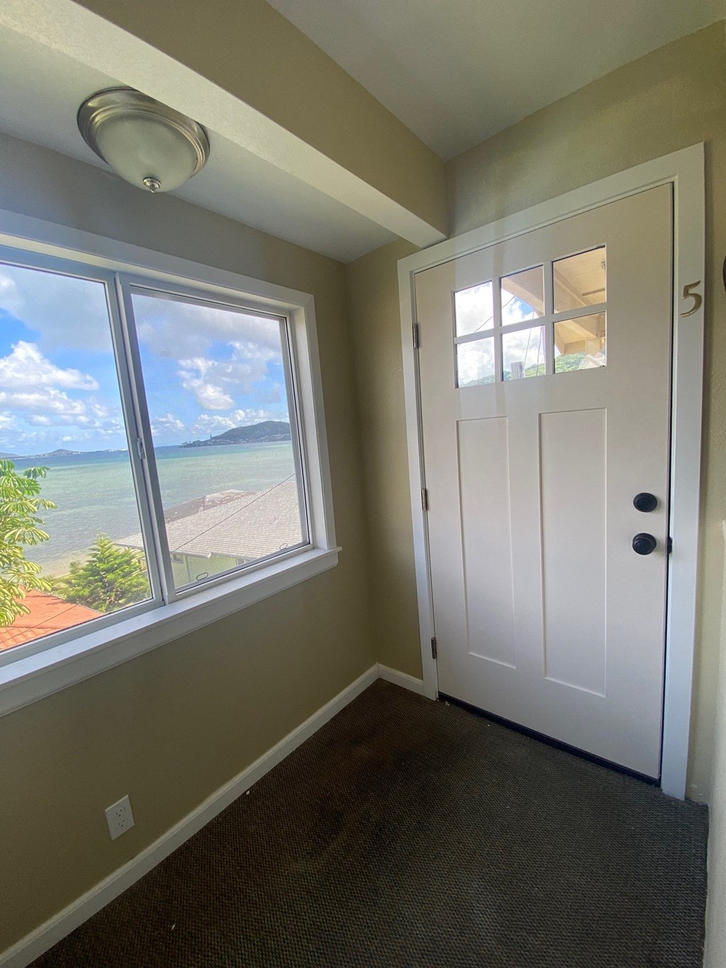 a room with a door and a window with a view of the water