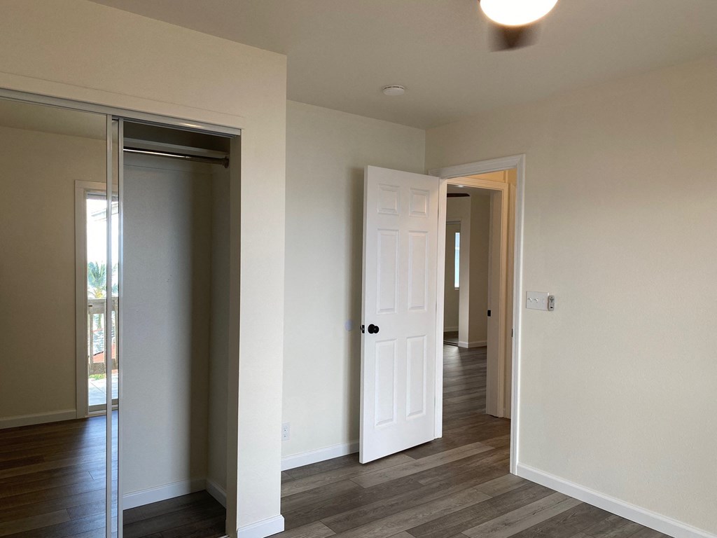 a master bedroom with a door to a hallway and a closet