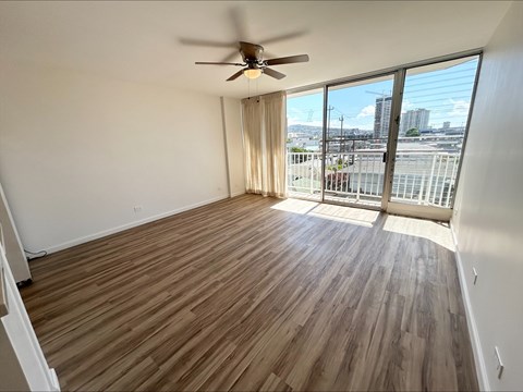 A room with a ceiling fan and sliding glass doors.