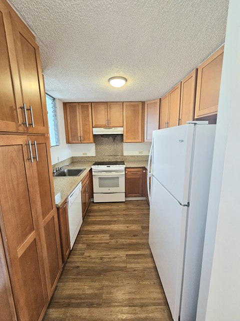 A kitchen with wooden cabinets and a white refrigerator.