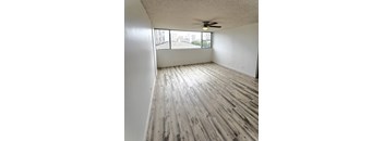 an empty living room with wood flooring and a window