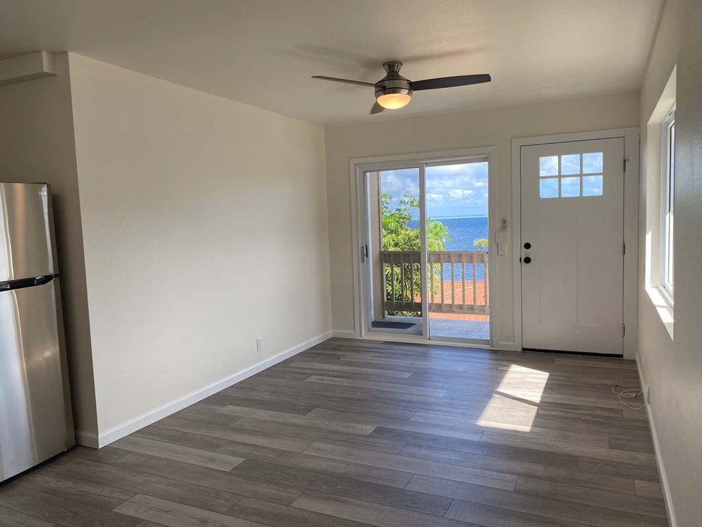 an empty living room with a door to a balcony