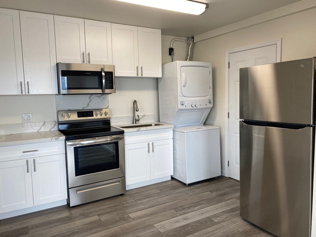 a kitchen with stainless steel appliances and white cabinets