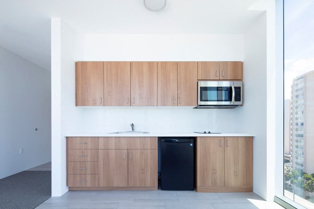 a kitchen with wooden cabinets and a black dishwasher and a microwave
