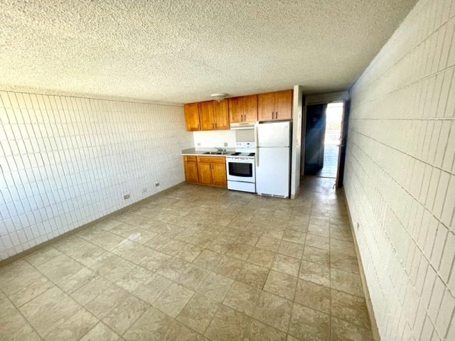 a kitchen with a white stove top oven next to a refrigerator