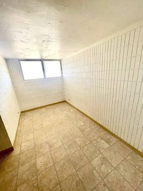 an empty room with a window and tiled floor