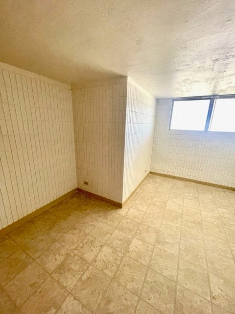 an empty room with a window and tiled floor