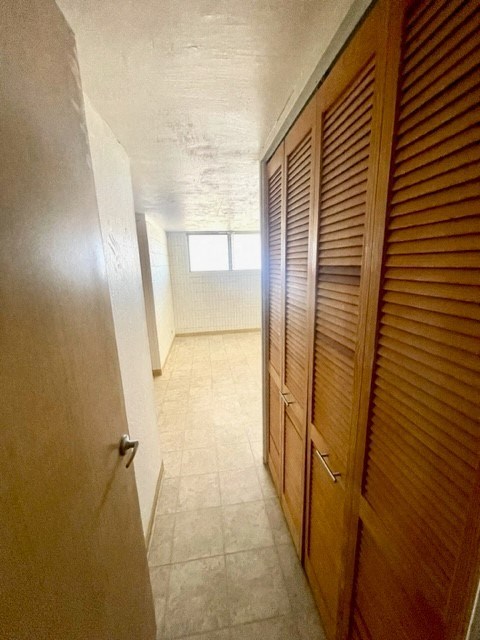 a hallway with a wooden door and tile floor