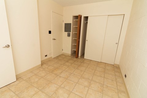 a room with a tiled floor and two closets