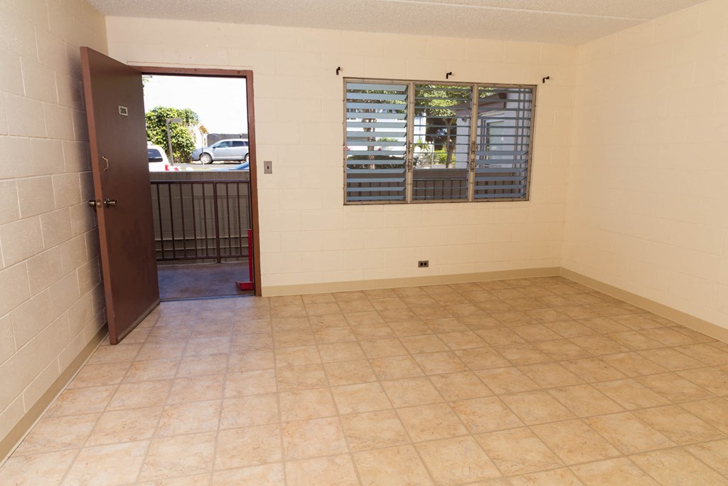 an empty room with a window and a door to a balcony
