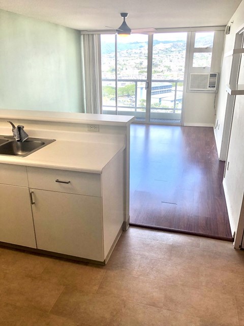 A kitchen with white cabinets and a black sink.