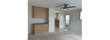 an empty kitchen with a ceiling fan and wooden cabinets