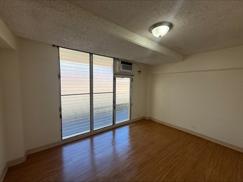 A room with a sliding glass door leading to a balcony.