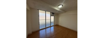 A room with a sliding glass door leading to a balcony.
