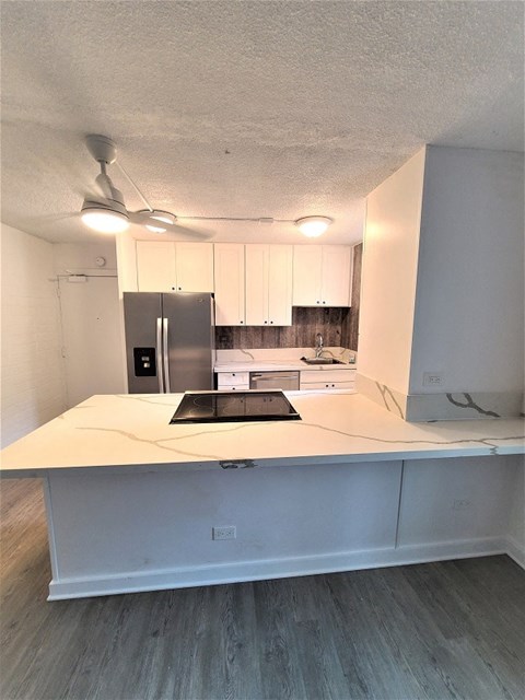 A kitchen with a white countertop and a black cutting board.
