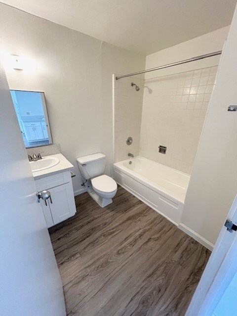 A white bathroom with a toilet, sink, and bathtub.