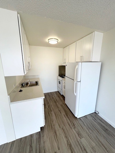 A small kitchen with white appliances and cabinets.