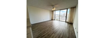 A room with wooden flooring and a ceiling fan.
