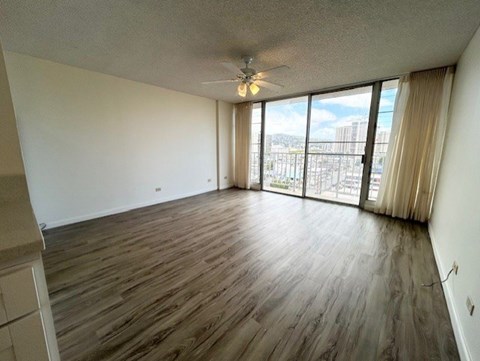 A room with wooden flooring and a ceiling fan.