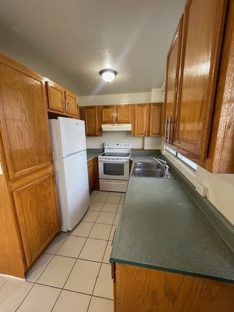 A kitchen with wooden cabinets and white appliances.