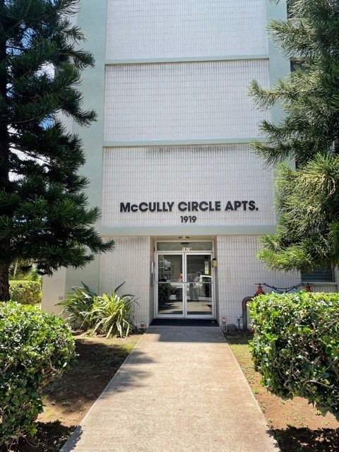 a white building with a sidewalk in front of a door