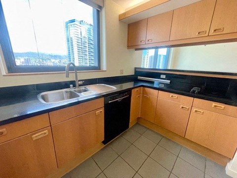 A kitchen with wooden cabinets and black countertops.