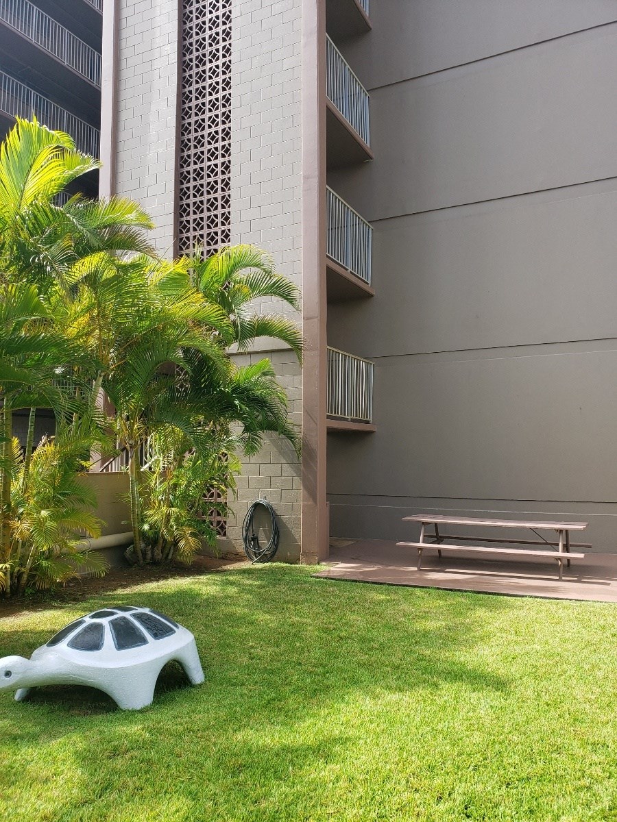 a piece of art sits on the grass in front of a building