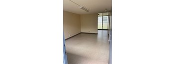 an empty room with a white floor and a door