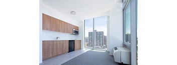 an empty room with a large window and a kitchen