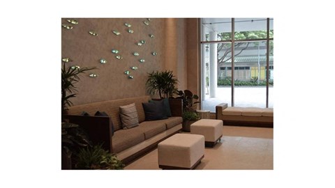 A living room with a couch, a table, and a wall with butterflies.