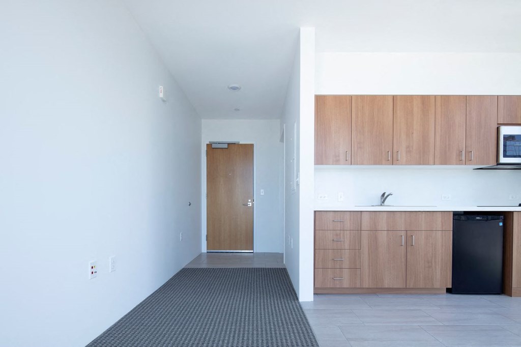 an empty room with a kitchen and a door