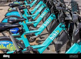 a row of blue bikes parked next to each other