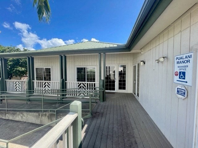 a building with a wooden deck and a green roof