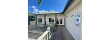 a building with a wooden deck and a green roof
