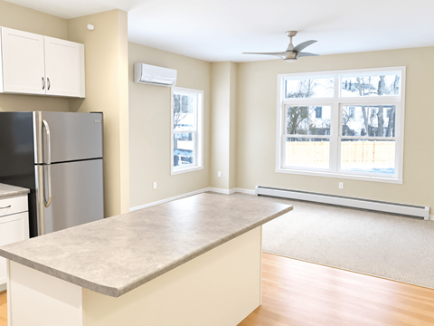 A kitchen with a refrigerator, a counter, and a window.