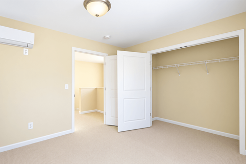 A room with a white door and a white closet door.