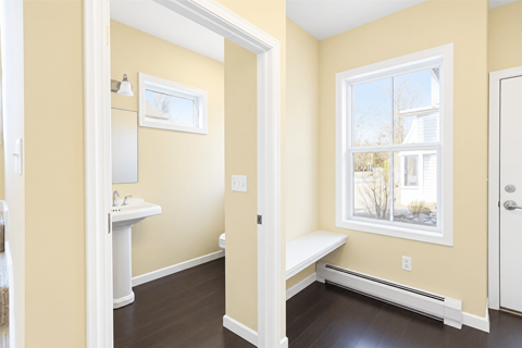 A bathroom with a window seat and a white sink vanity.
