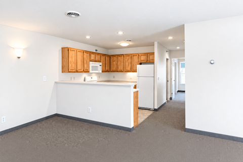 A kitchen with white appliances and wooden cabinets.