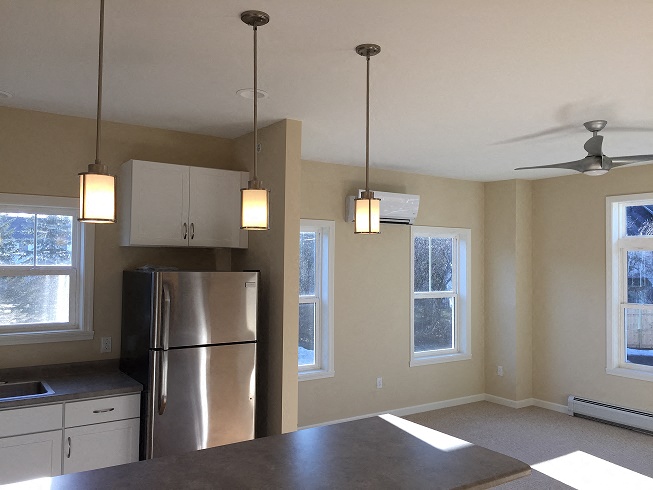 Hayes Kitchen facing living room with overhead light fixtures and four exterior windows