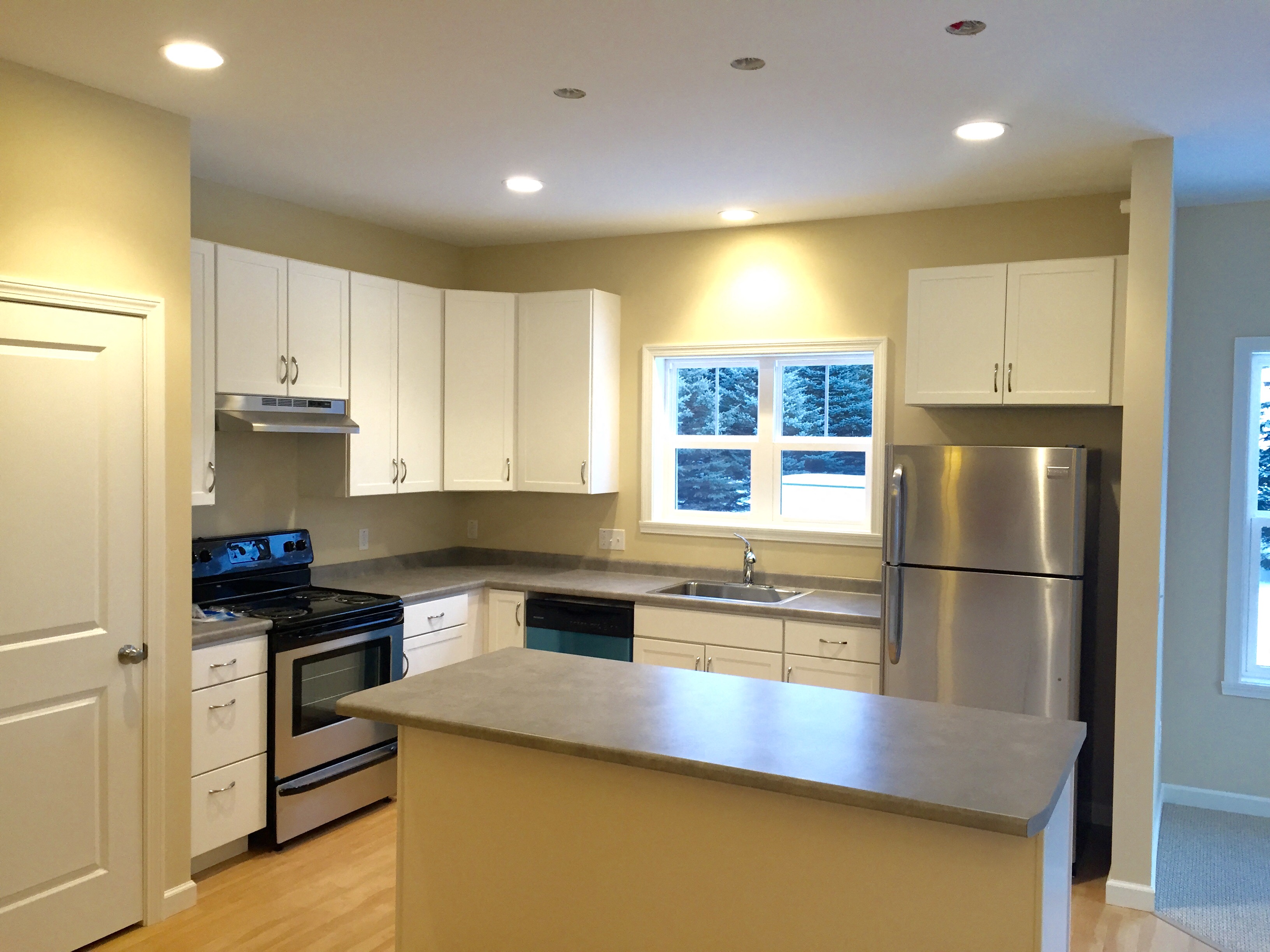 a kitchen with white cabinets and stainless steel appliances