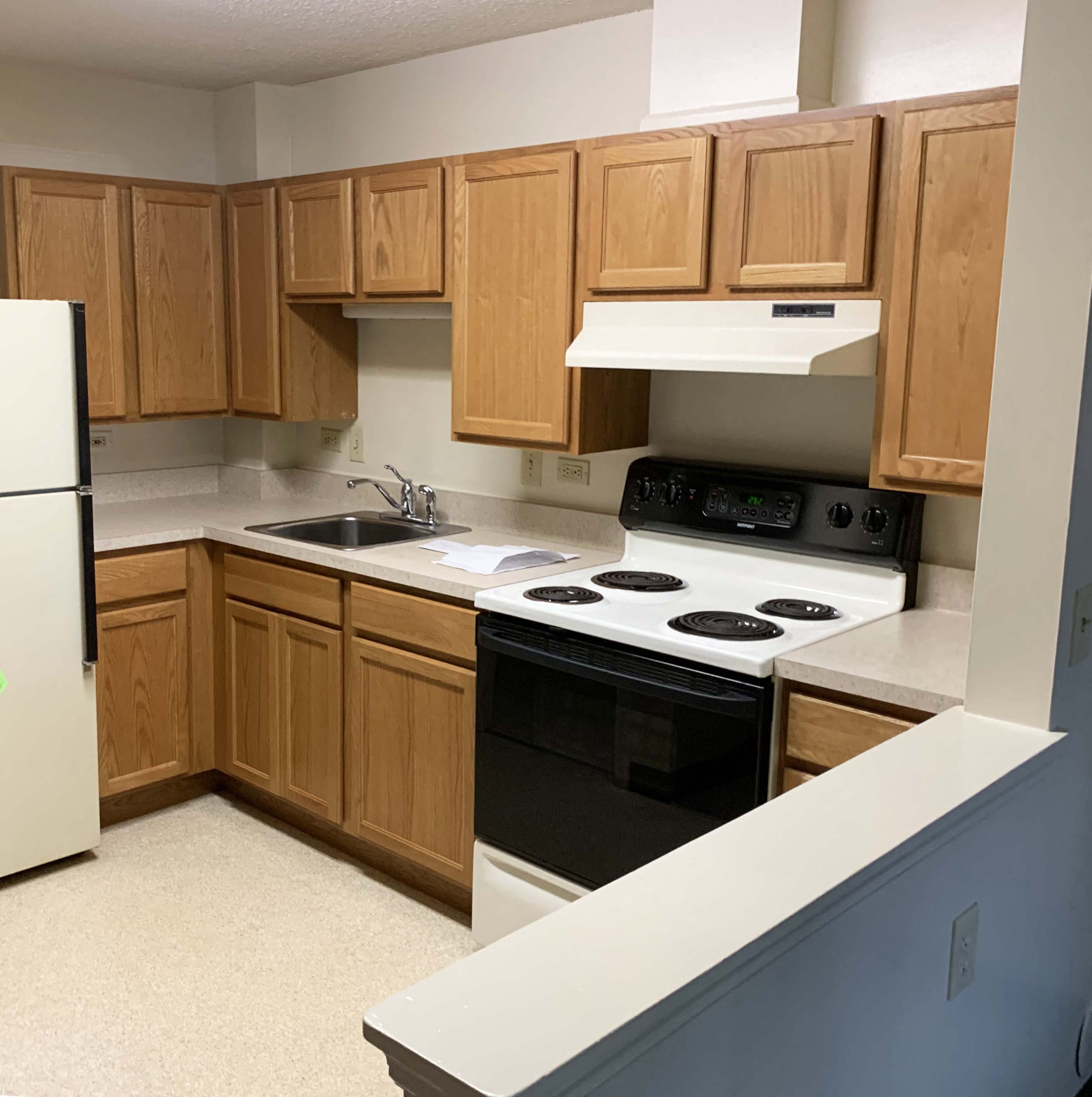 a kitchen with wooden cabinets and a stove and a sink