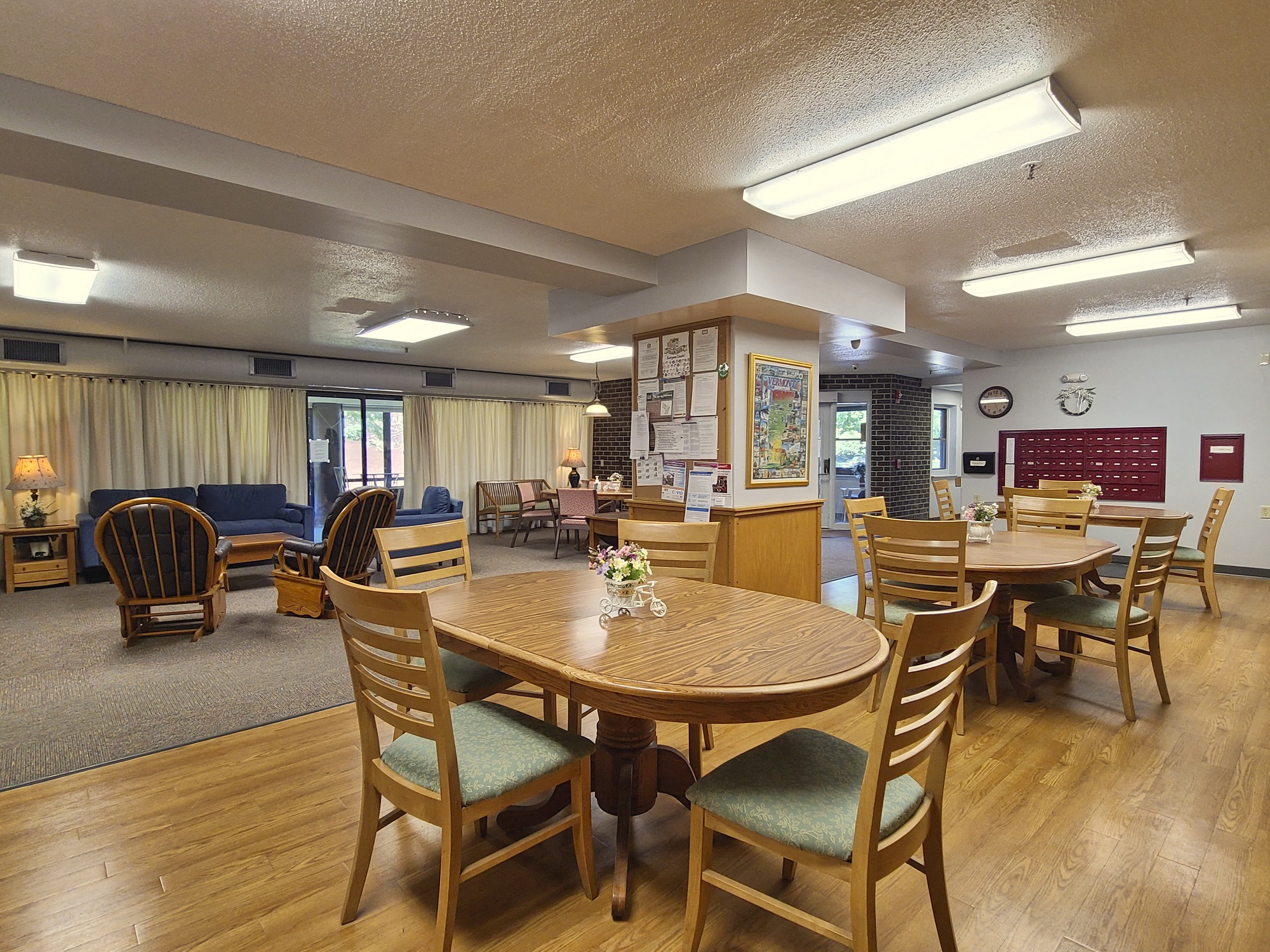 McKenzie House common room with seating area, community board and resident mailboxes