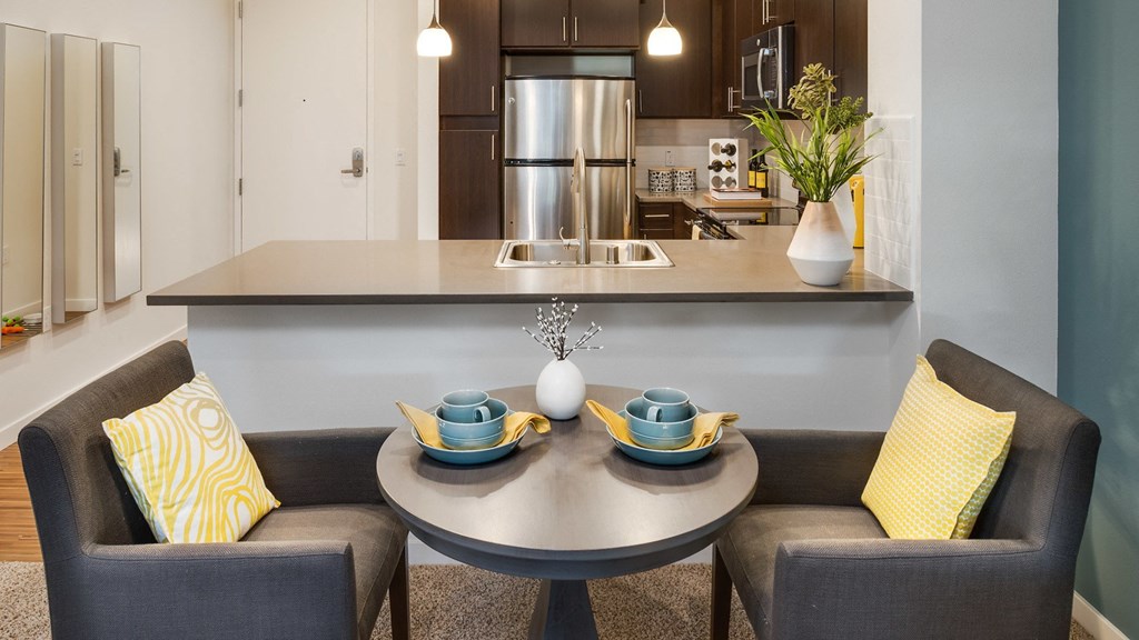 a kitchen and living room with a table and chairs