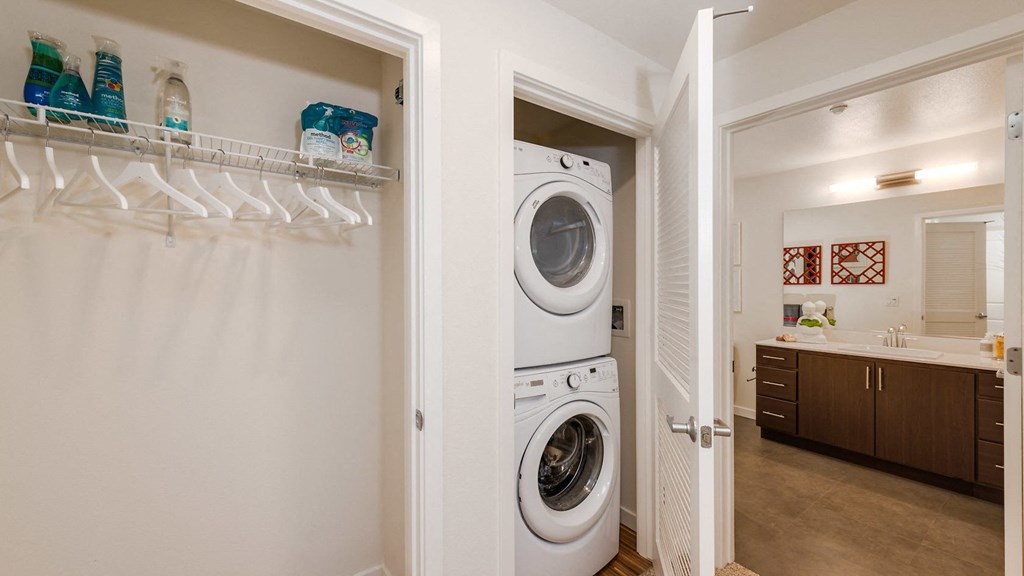 a washer and dryer in a closet in a home with a bathroom