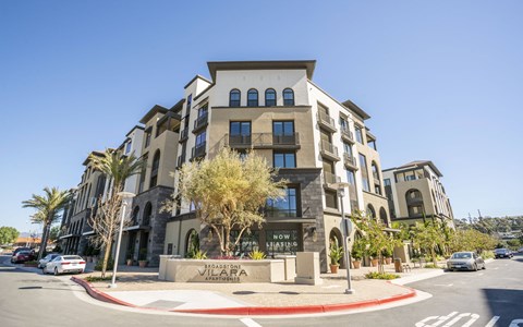 A modern building with the words "Now is the Time" on a sign in front of it.