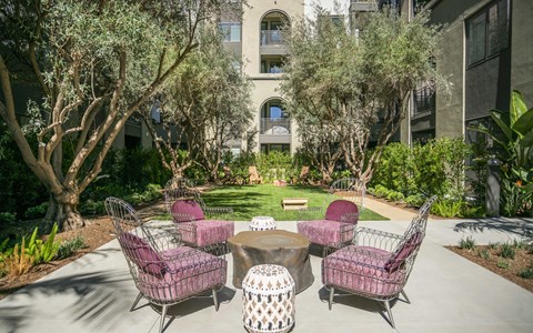 A patio with a table and chairs surrounded by trees.