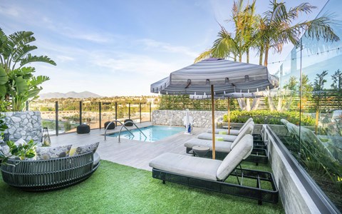 A modern outdoor seating area with a pool and a view of the mountains.