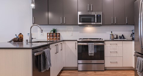 A modern kitchen with a stainless steel oven and white cabinets.
