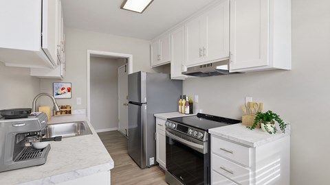 A kitchen with white cabinets and stainless steel appliances.